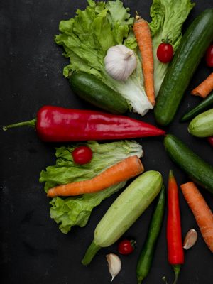 Kreis aus verschiedenem Gemüse für Ergänzungsfuttermittel auf schwarzen Untergrund. U.a. Paprika, Karotte, Salat, Gurke, Tomate und Knoblauch